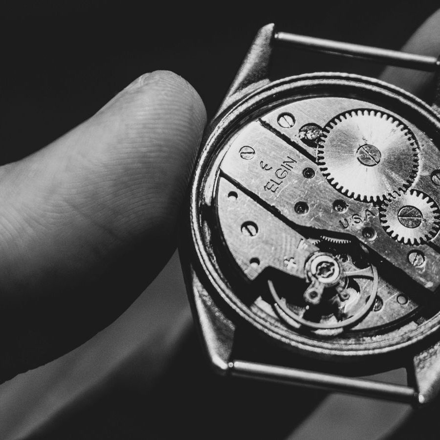 Otwarta koperta zegarka trzymana w dłoni — widoczny mechanizm