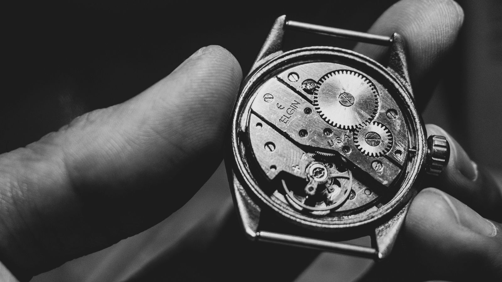 Otwarta koperta zegarka trzymana w dłoni — widoczny mechanizm